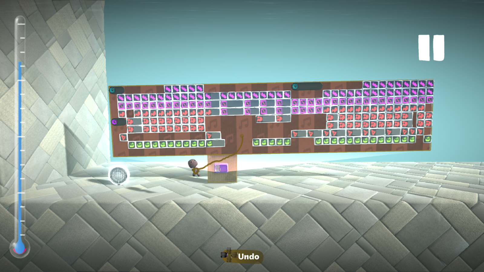 A nearly full, blue thermometer on the left is accompanied by a music sequencer microchip in littlebigplanet 2